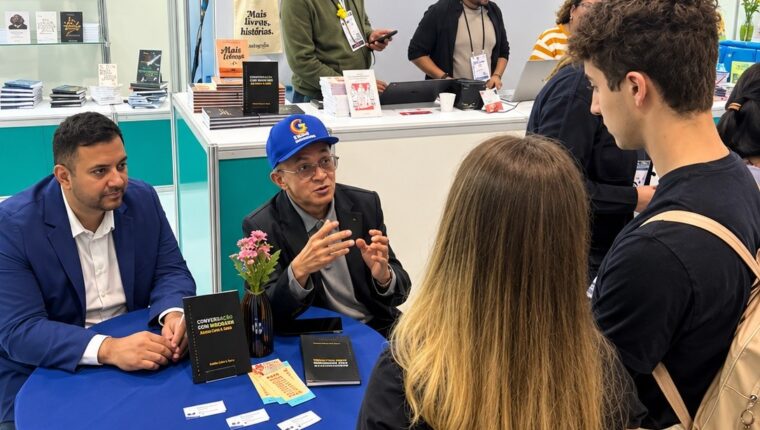 Professor Bibiano Costa de boné azul durante autógrafos na Bienal.