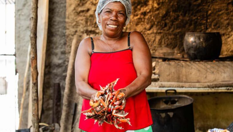 Mulher com caranguejos no litoral sul da Bahia
